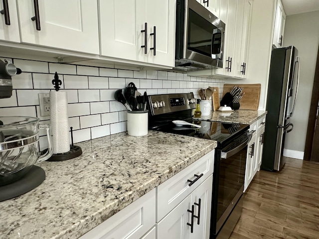 923 Riverview Rd, Marshfield, MO 65706 - kitchen featuring appliances with stainless steel finishes, backsplash, white cabinets, light stone countertops, and dark wood finished floors