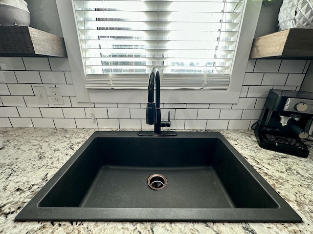 923 Riverview Rd, Marshfield, MO 65706 - kitchen view of a sink, tasteful backsplash, and light stone countertops