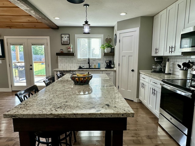 923 Riverview Rd, Marshfield, MO 65706 - kitchen featuring appliances with stainless steel finishes, a sink, tasteful backsplash, white cabinetry, and healthy amount of natural light