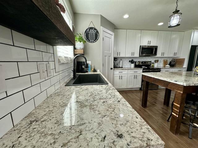 923 Riverview Rd, Marshfield, MO 65706 - kitchen with range with electric cooktop, stainless steel microwave, a sink, backsplash, and white cabinetry