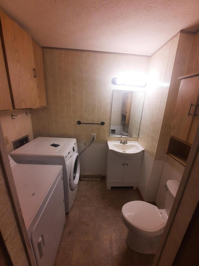 2504 N Clayton Ave, Springfield, MO 65803 - bathroom featuring washing machine and clothes dryer, toilet, vanity, and a textured ceiling