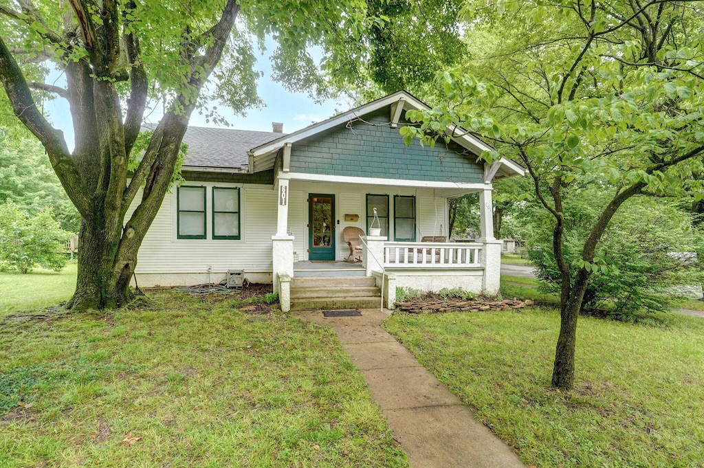 601 S Madison Ave, Aurora, MO 65605 - bungalow featuring a porch, a front lawn, and roof with shingles