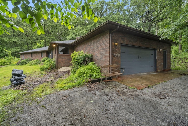 401 Honeysuckle Dr, Marshfield, MO 65706 - view of home's exterior featuring brick siding, an attached garage, and asphalt driveway