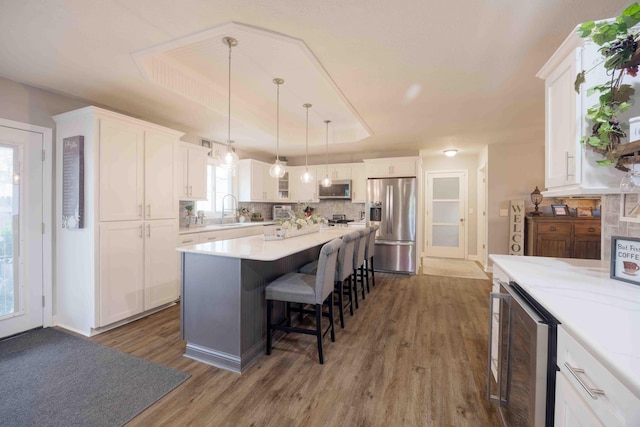 248 Charles Rd, Billings, MO 65610 - kitchen with wine cooler, stainless steel appliances, a sink, a raised ceiling, and white cabinets