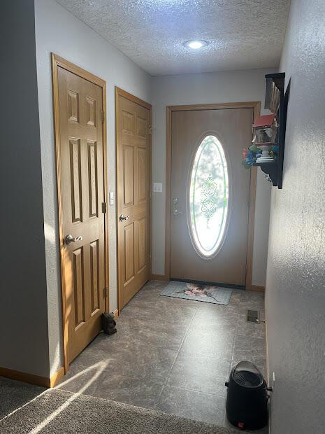 4120 S 119th Rd, Bolivar, MO 65613 - foyer entrance with a textured ceiling and baseboards