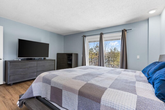 25451 County Road 327, Urbana, MO 65767 - bedroom featuring wood finished floors and a textured ceiling