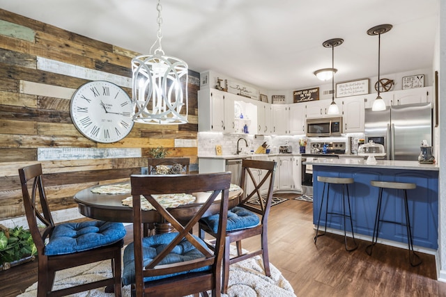 150 Sunken Forest Dr Unit 106, Forsyth, MO 65653 - dining space with wooden walls, a chandelier, and dark wood finished floors