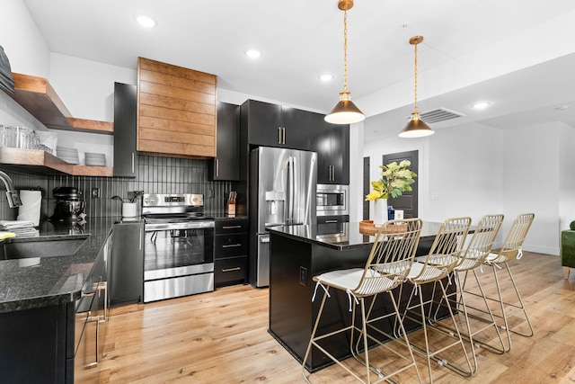 400 Poolside Pass, Hollister, MO 65672 - kitchen with stainless steel appliances, dark cabinetry, open shelves, a kitchen bar, and decorative backsplash