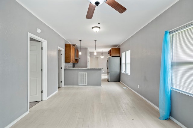 318 W Olive St, Aurora, MO 65605 - unfurnished living room featuring light wood-style flooring, a ceiling fan, and baseboards