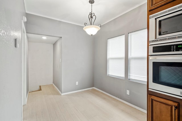 318 W Olive St, Aurora, MO 65605 - unfurnished dining area featuring light wood-style flooring and baseboards