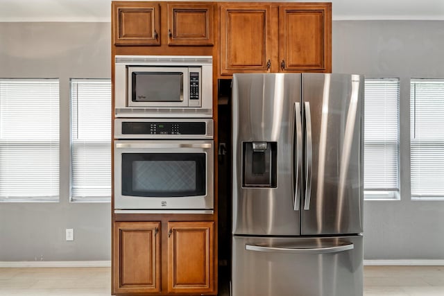 318 W Olive St, Aurora, MO 65605 - kitchen featuring stainless steel appliances, brown cabinetry, plenty of natural light, and baseboards