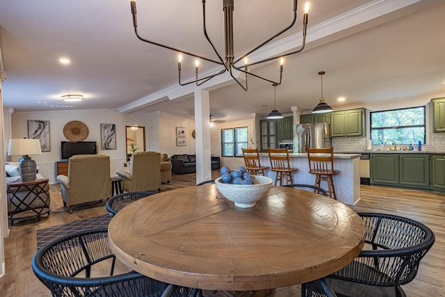 25832 County Road 250, Hermitage, MO 65668 - dining area with healthy amount of natural light, light wood-style floors, vaulted ceiling, a chandelier, and crown molding