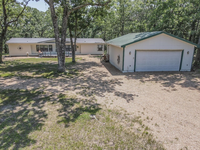 25832 County Road 250, Hermitage, MO 65668 - ranch-style house featuring a garage, metal roof, and view of wooded area