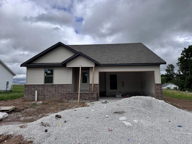 356 N Oak Ave, Sparta, MO 65753 - view of front of property with brick siding, a garage, a shingled roof, and gravel driveway