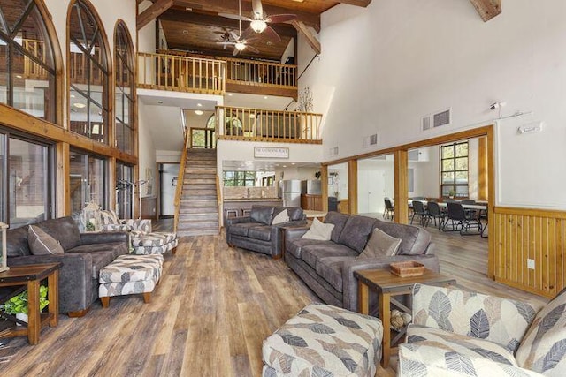 234 Sunset Cv Unit 107, Branson, MO 65616 - living area with a high ceiling, wood finished floors, ceiling fan, beamed ceiling, and a wainscoted wall