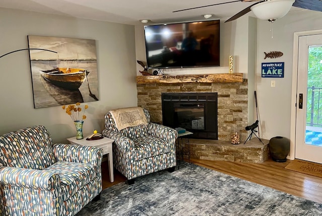 234 Sunset Cv Unit 107, Branson, MO 65616 - living room with wood finished floors, a stone fireplace, and ceiling fan