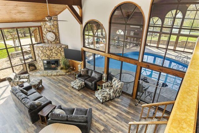 234 Sunset Cv Unit 107, Branson, MO 65616 - living area with ceiling fan, wood finished floors, a fireplace, lofted ceiling, and wood ceiling