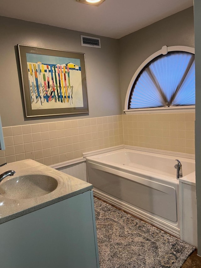234 Sunset Cv Unit 107, Branson, MO 65616 - bathroom with tile walls, a garden tub, and vanity