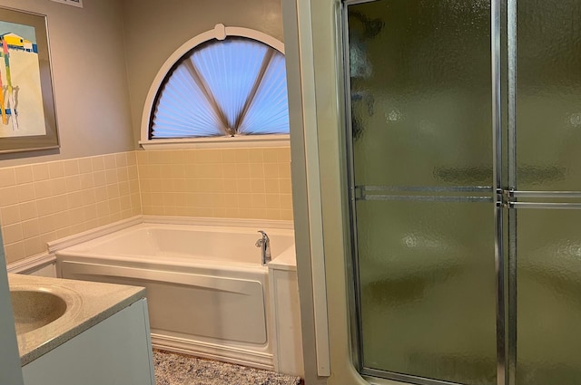 234 Sunset Cv Unit 107, Branson, MO 65616 - full bathroom featuring vanity, a garden tub, a stall shower, and tile walls