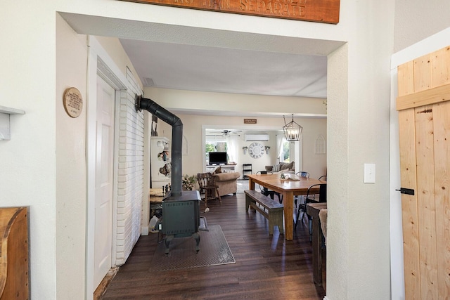 214 Rudolph St, Seymour, MO 65746 - dining room with a wood stove, wood finished floors, an AC wall unit, and ceiling fan