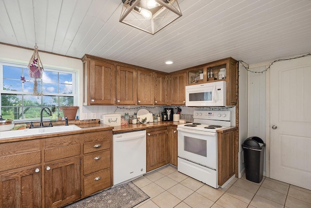 214 Rudolph St, Seymour, MO 65746 - kitchen with white appliances, a sink, brown cabinets, light tile patterned floors, and light countertops