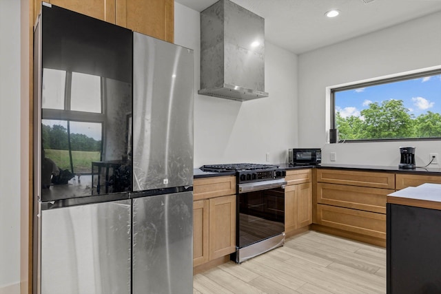 176 Shooting Star Ln, Nixa, MO 65714 - kitchen with stainless steel appliances, wall chimney range hood, light wood-style flooring, dark countertops, and recessed lighting