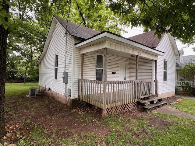 2033 N Grant Ave, Springfield, MO 65803 - view of front facade with central AC, a shingled roof, and covered porch