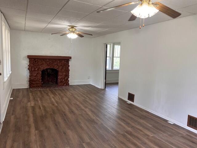 935 W Brower St, Springfield, MO 65802 - unfurnished living room featuring ceiling fan, dark wood-type flooring, baseboards, a paneled ceiling, and a stone fireplace
