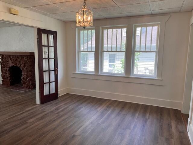 935 W Brower St, Springfield, MO 65802 - unfurnished dining area with baseboards, dark wood-style flooring, a chandelier, and a stone fireplace