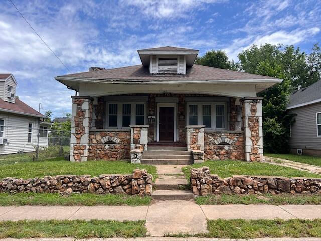 935 W Brower St, Springfield, MO 65802 - view of front of house with stone siding, a porch, and a front lawn