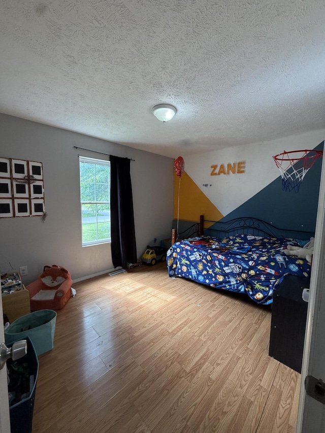 208 Justin St, Rogersville, MO 65742 - bedroom with wood finished floors and a textured ceiling