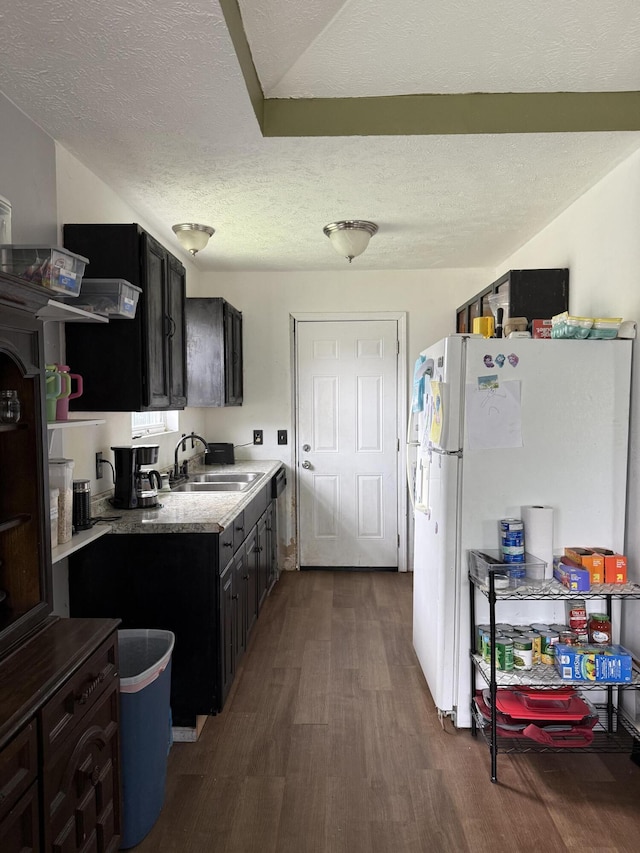 208 Justin St, Rogersville, MO 65742 - kitchen featuring a sink, freestanding refrigerator, dark wood-style flooring, a textured ceiling, and dark cabinets