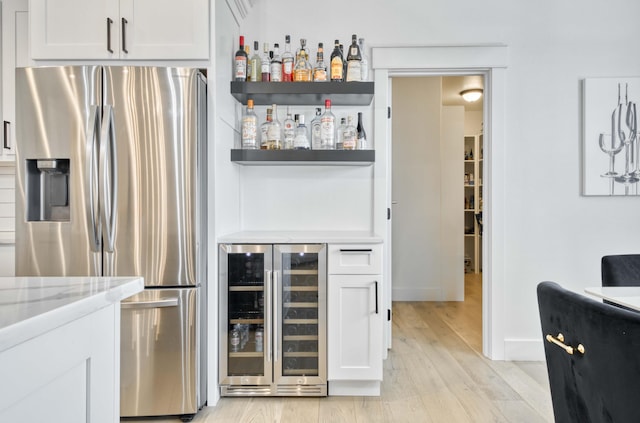 1674 N Marlowe Ave, Springfield, MO 65802 - indoor dry bar featuring stainless steel fridge with ice dispenser, wine cooler, and light wood-style floors