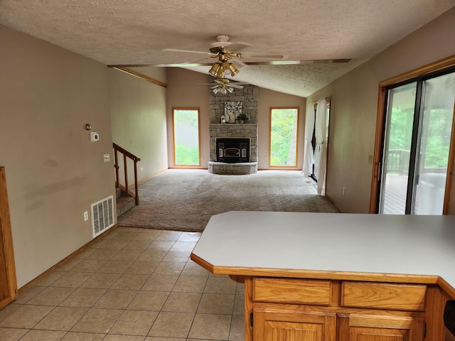 29039 Nottinghill Dr, Shell Knob, MO 65747 - living area with a textured ceiling, vaulted ceiling, ceiling fan, a stone fireplace, and stairs