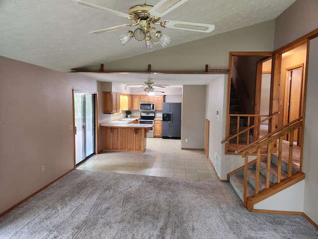 29039 Nottinghill Dr, Shell Knob, MO 65747 - kitchen with stainless steel appliances, lofted ceiling, a ceiling fan, a peninsula, and light carpet