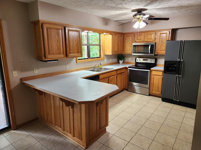 29039 Nottinghill Dr, Shell Knob, MO 65747 - kitchen with stainless steel appliances, light countertops, a peninsula, light tile patterned floors, and a textured ceiling