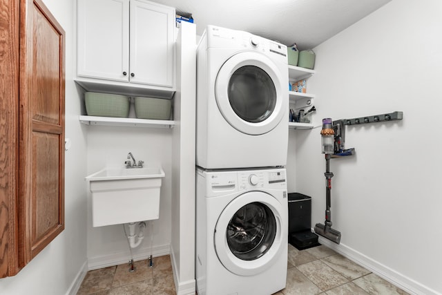 2029 Moon Valley Rd, Ozark, MO 65721 - laundry room featuring stacked washing machine and dryer, cabinet space, and baseboards