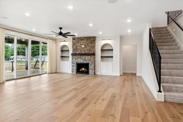 4943 S Aaron Ave, Springfield, MO 65810 - unfurnished living room featuring light wood-style flooring, recessed lighting, ceiling fan, stairs, and a stone fireplace