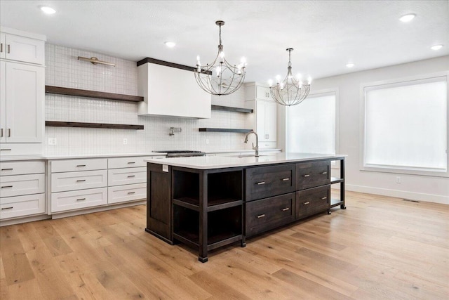 4943 S Aaron Ave, Springfield, MO 65810 - kitchen featuring open shelves, light countertops, a sink, a chandelier, and light wood-style flooring