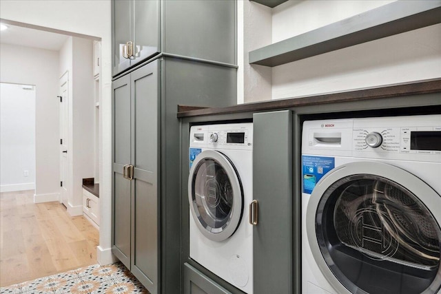 4943 S Aaron Ave, Springfield, MO 65810 - laundry room with washer / clothes dryer, baseboards, light wood-style floors, and cabinet space