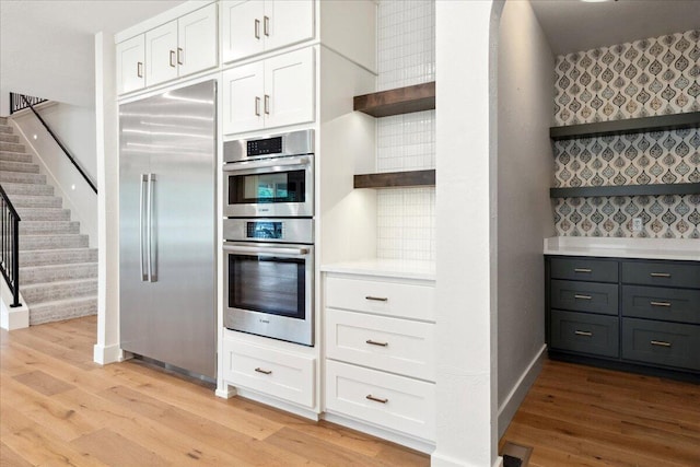 4943 S Aaron Ave, Springfield, MO 65810 - kitchen with open shelves, appliances with stainless steel finishes, wallpapered walls, white cabinets, and light wood finished floors