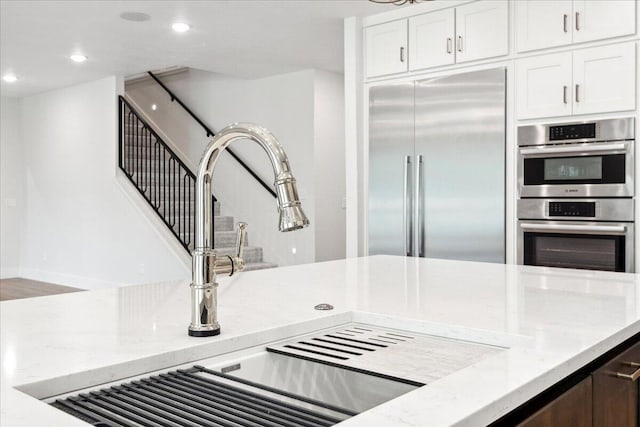 4943 S Aaron Ave, Springfield, MO 65810 - kitchen featuring appliances with stainless steel finishes, light stone counters, white cabinetry, recessed lighting, and a sink