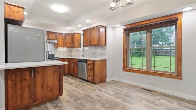 2606 Country Dr, Mountain Grove, MO 65711 - kitchen with appliances with stainless steel finishes, under cabinet range hood, brown cabinetry, light countertops, and recessed lighting