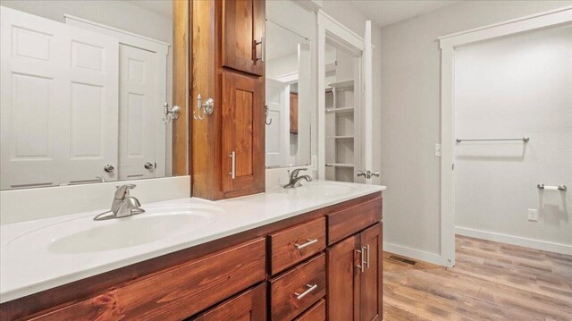 2606 Country Dr, Mountain Grove, MO 65711 - bathroom with double vanity, wood finished floors, and baseboards