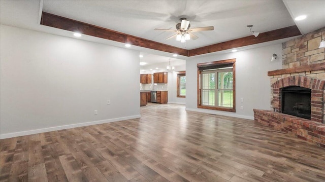 2606 Country Dr, Mountain Grove, MO 65711 - unfurnished living room with a fireplace, ceiling fan, wood finished floors, a chandelier, and beam ceiling