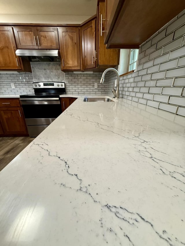 2606 Country Dr, Mountain Grove, MO 65711 - kitchen featuring stainless steel electric range, decorative backsplash, under cabinet range hood, and light stone countertops