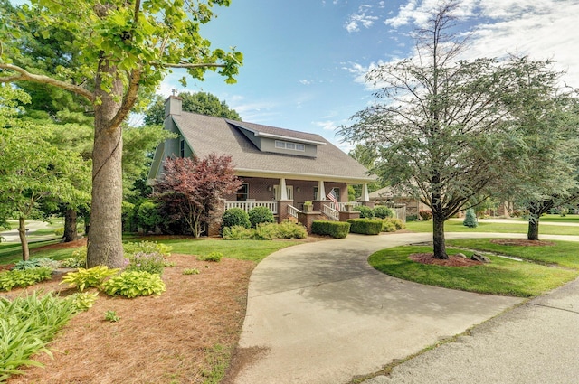 401 E Glendale St, Aurora, MO 65605 - view of front of house with covered porch, curved driveway, a chimney, and a front lawn
