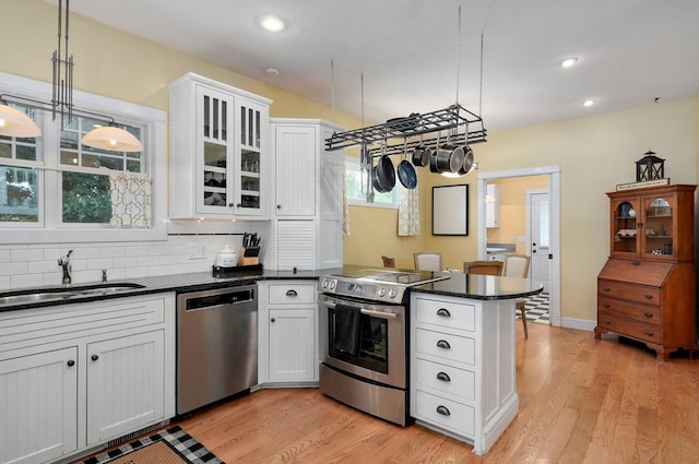 401 E Glendale St, Aurora, MO 65605 - kitchen with appliances with stainless steel finishes, a sink, a peninsula, light wood-style floors, and decorative backsplash
