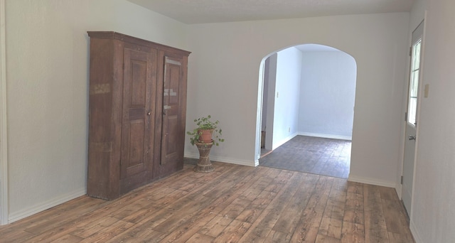 221 Boisseau St, Greenfield, MO 65661 - empty room with arched walkways, hardwood / wood-style flooring, and baseboards