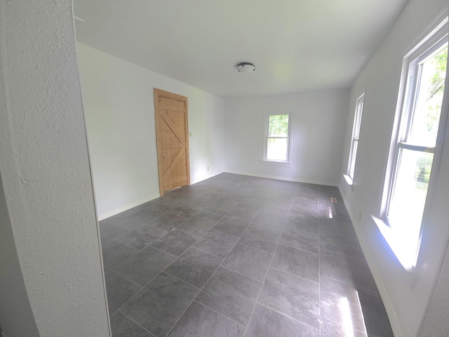 221 Boisseau St, Greenfield, MO 65661 - unfurnished room featuring baseboards and dark tile patterned floors